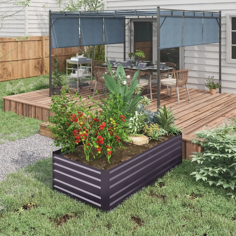 Backyard raised garden bed with vegetables beside wooden patio and outdoor dining area.