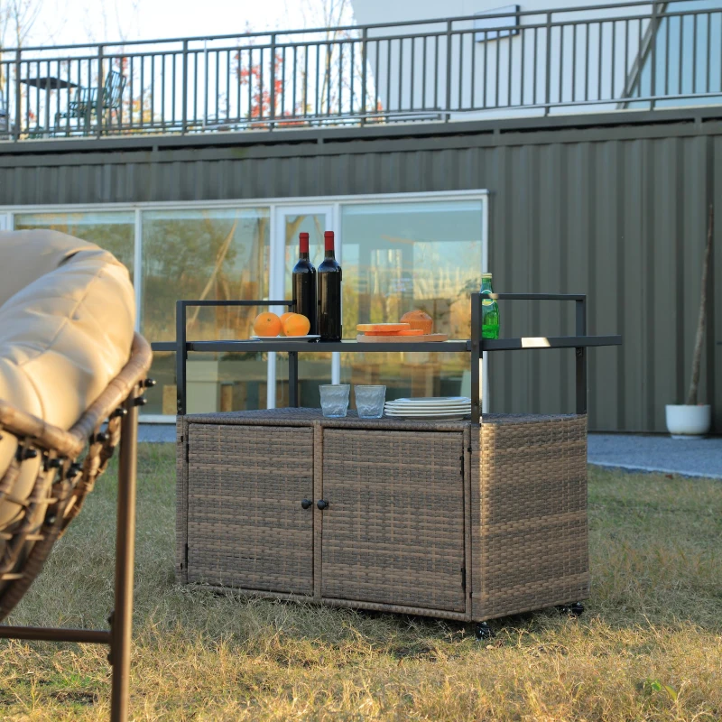Outdoor wicker bar cart with wine bottles, glasses, and citrus setup for backyard entertaining.