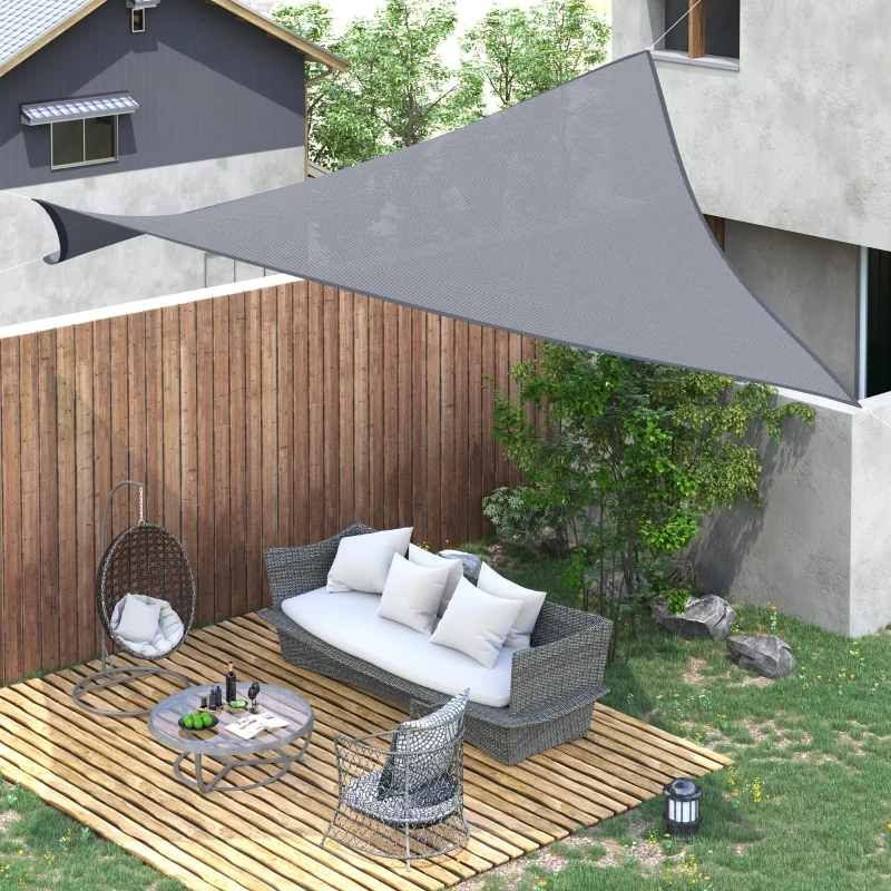 Modern backyard with gray triangle sun shade sail and outdoor seating area.