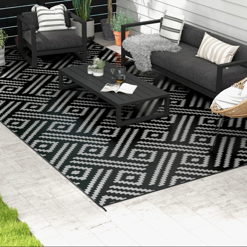 Black and white patterned rug in modern outdoor space with furniture.
