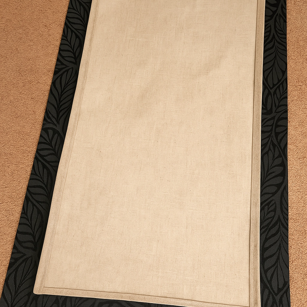 Measuring beige fabric with black patterned border for accurate tailoring or stitching