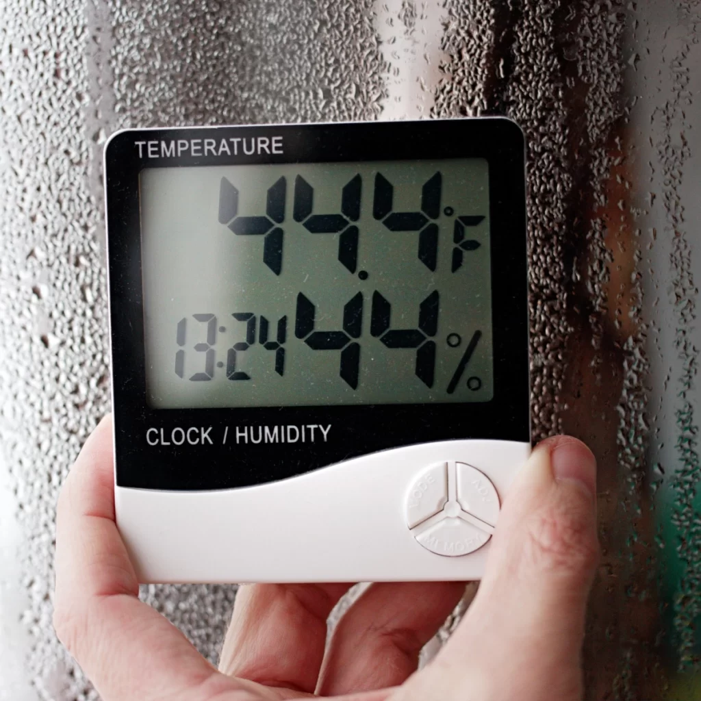 Thermometer displaying temperature and humidity inside a greenhouse.