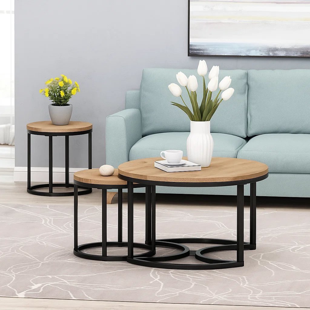 Coffee table styled with tall white tulips in a white vase, books, and a soft blue sofa background.
