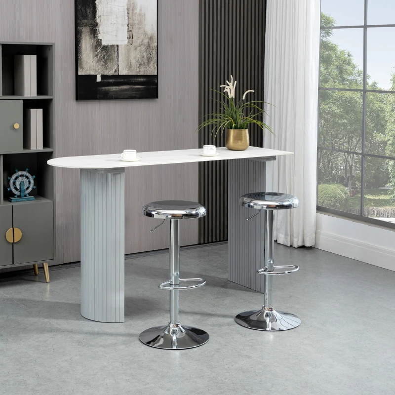 Modern backless chrome bar stools with footrests in a bright room with large window.
