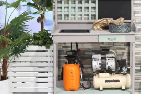 Outdoor potting station with potted plants, watering cans, and decorative gardening tools.