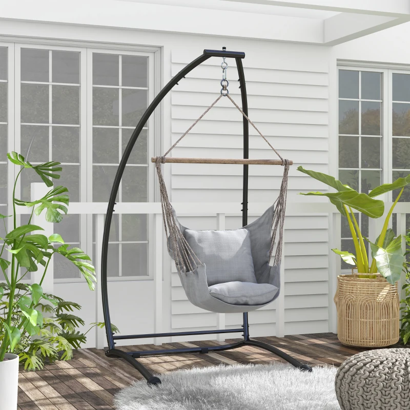 Beige hammock chair suspended from a black C-stand on a wooden deck.