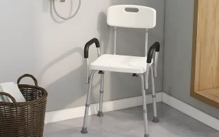 White shower chair with black armrests placed in a corner of a tiled bathroom