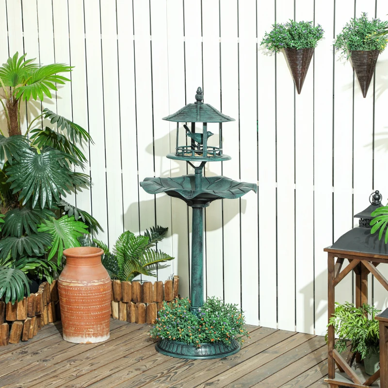 Bird bath surrounded by plants, clean and decorated with a leafy design.