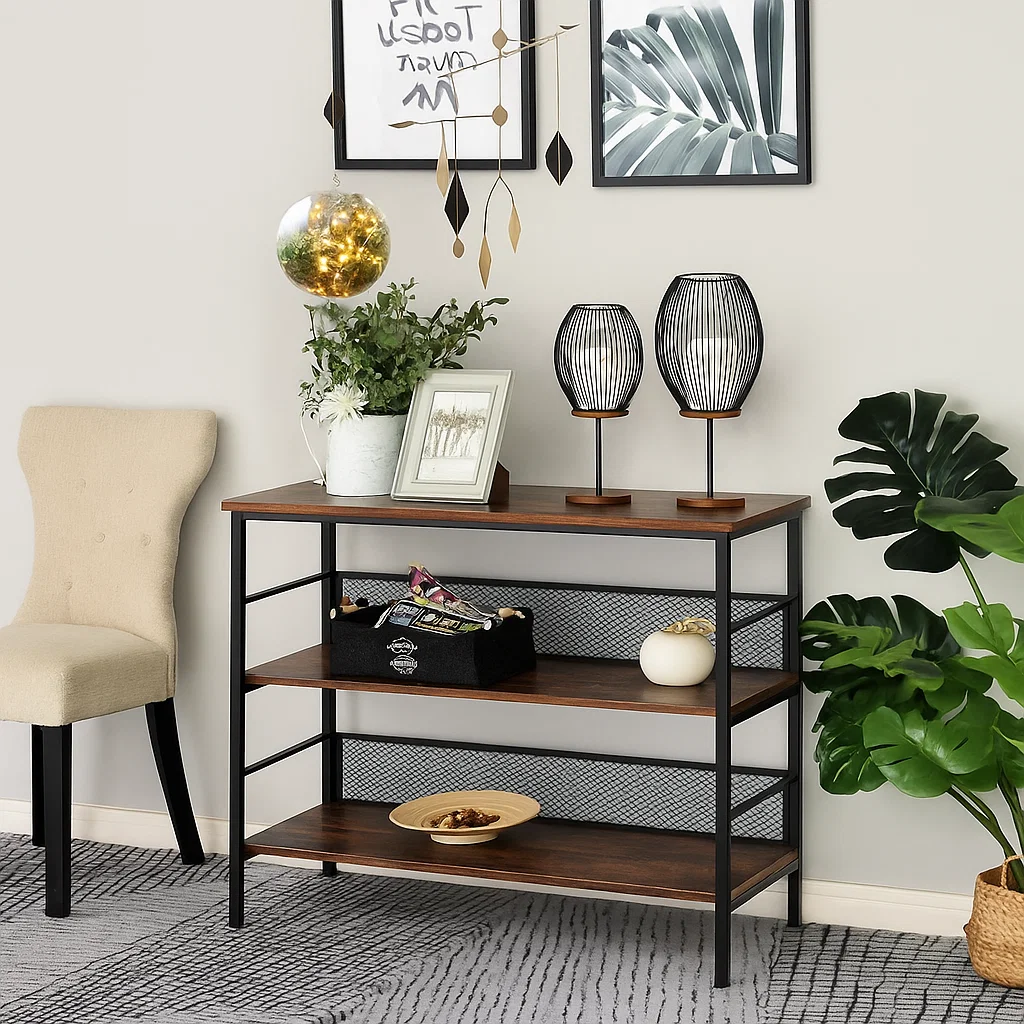 Decorated console table with black lamps, framed art, hanging mobile, and layered greenery accents.
