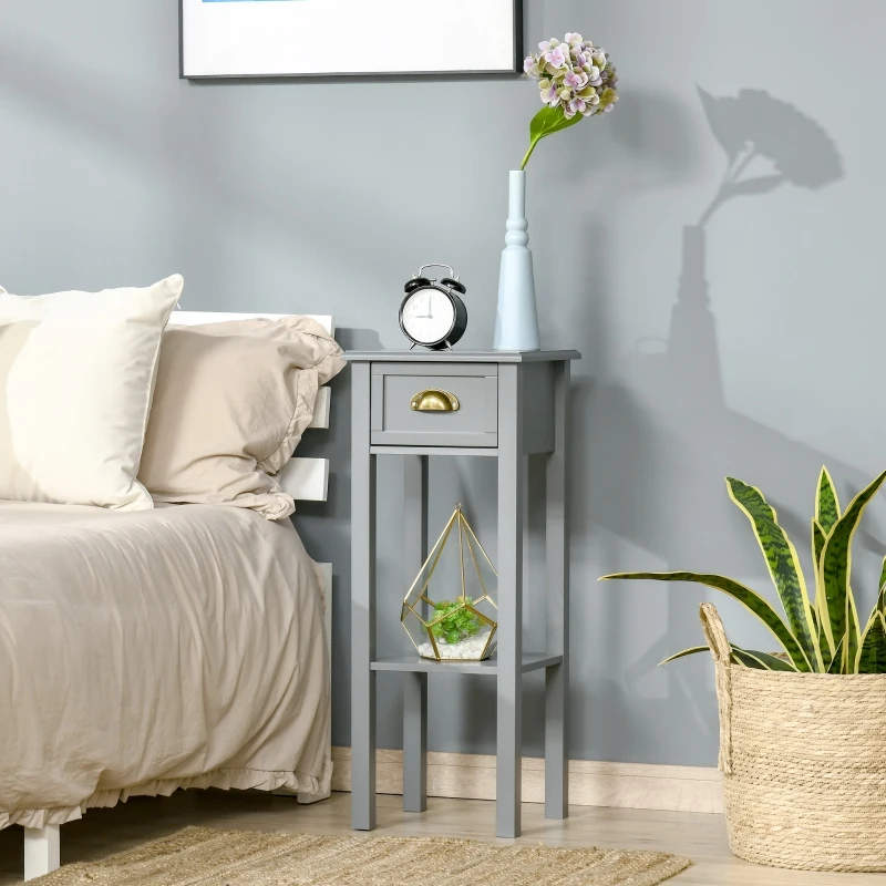Wooden end table with plant decor beside a bed.