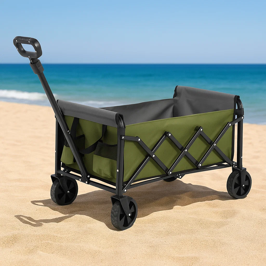 Wide-wheel beach wagon carrying towels and a cooler on sandy beach near ocean.