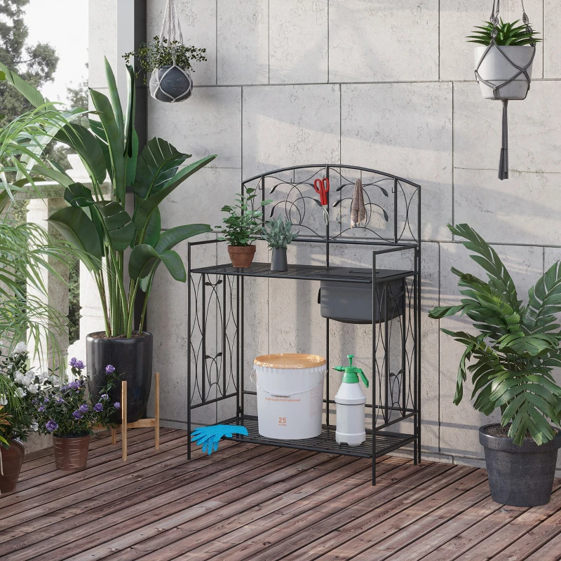 Compact foldable garden potting bench set up on patio with potted plants.