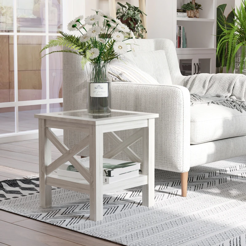 White end table beside sofa decorated with a clear vase of daisies and green foliage
