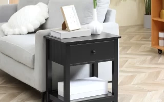 Black end table with drawer and lower shelf next to a gray sofa in a stylish living room.
