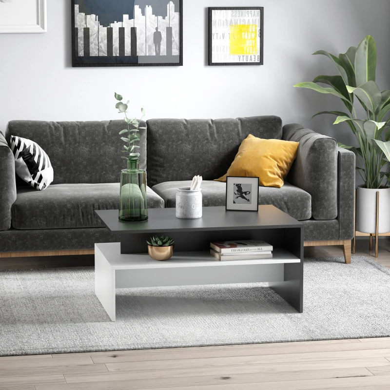 Modern living room with a two-tone coffee table, grey couch, framed art, and indoor plants.
