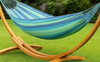 Colorful hammock hanging on wooden stand in backyard showcasing comfortable outdoor relaxation setup.