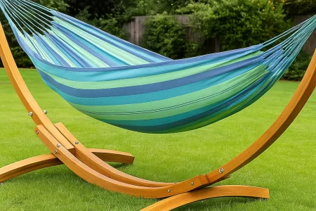 Colorful hammock hanging on wooden stand in backyard showcasing comfortable outdoor relaxation setup.