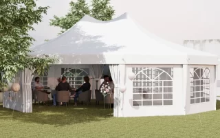 Group seated inside a large white outdoor canopy tent set up for a garden event