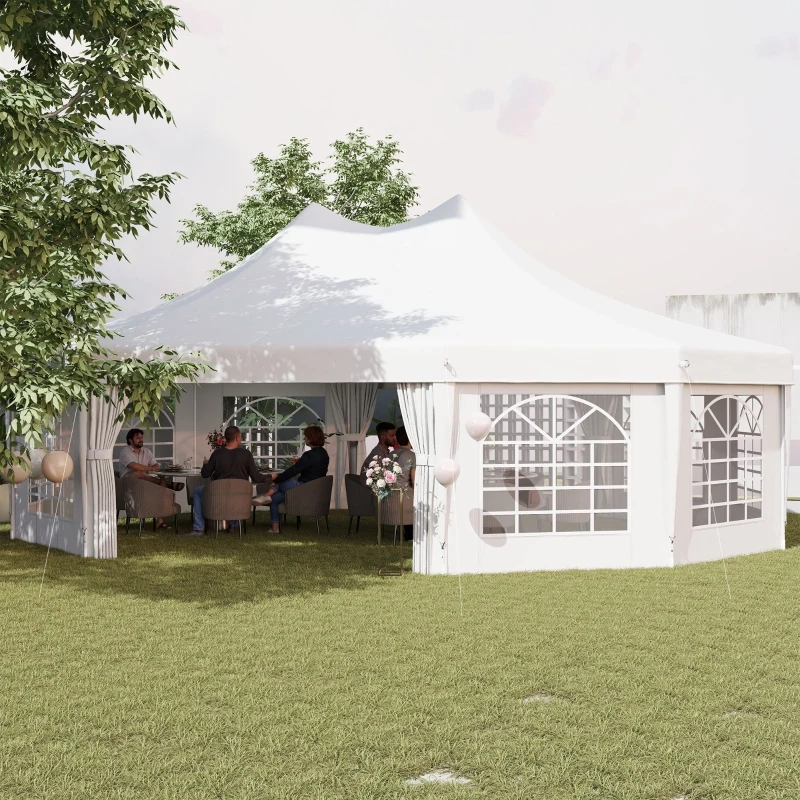 Group seated inside a large white outdoor canopy tent set up for a garden event.