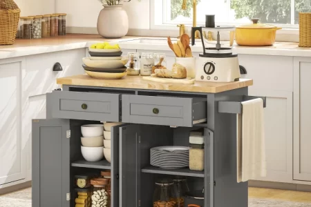 Grey kitchen island with open storage filled with plates, bowls, and glass jars.