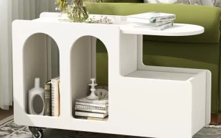Modern white end table on wheels styled with books, flowers, and curved cutouts for storage