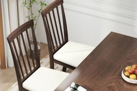 Two wooden dining chairs with freshly upholstered white seats near dining table
