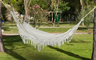 Camper bundled in a hammock with an insulated top quilt to stay warm outdoors