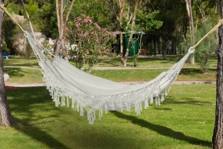 Camper bundled in a hammock with an insulated top quilt to stay warm outdoors