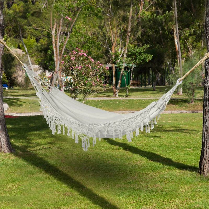 Camper bundled in a hammock with an insulated top quilt to stay warm outdoors.