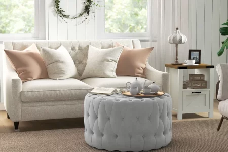 Velvet tufted ottoman with copper tray, serving tea and book, replacing a traditional coffee table.