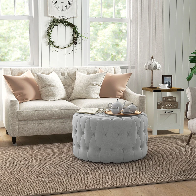Velvet tufted ottoman with copper tray, serving tea and book, replacing a traditional coffee table.
