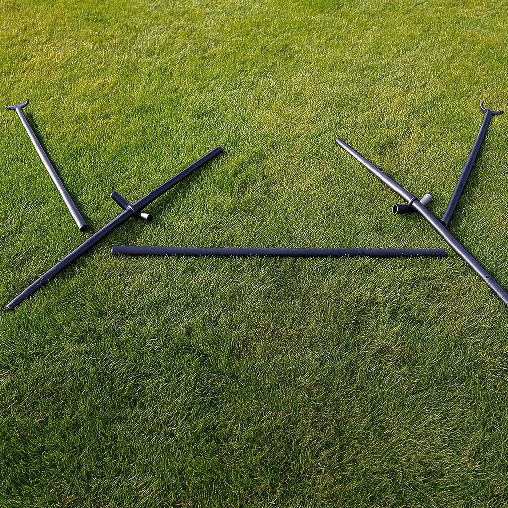 Metal hammock stand parts laid out on grass, ready for assembly.
