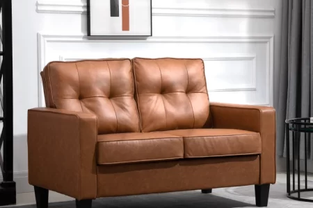 Brown faux leather loveseat with button-tufted cushions in a bright, stylish living room.