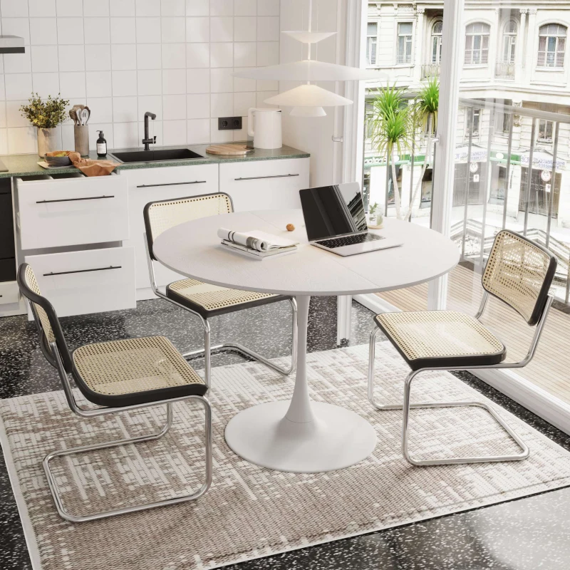 Compact round dining table with four chairs and tableware in a cozy apartment kitchen corner