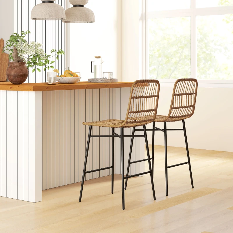 Two rattan and black metal bar stools at a wooden breakfast counter in a stylish kitchen.