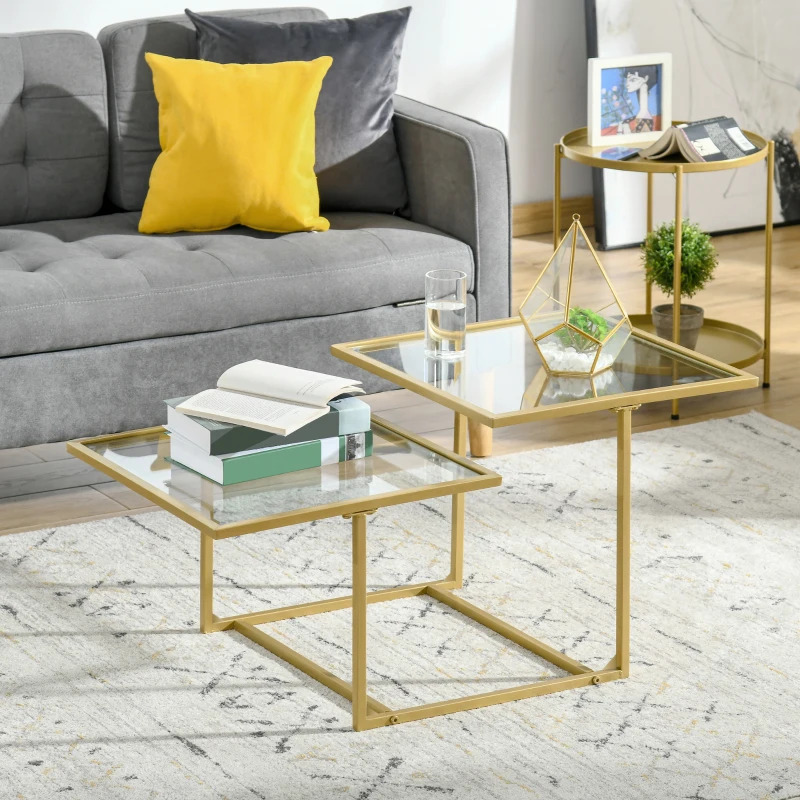 Stylish glass-top nesting tables with gold frames near a grey couch and modern rug.