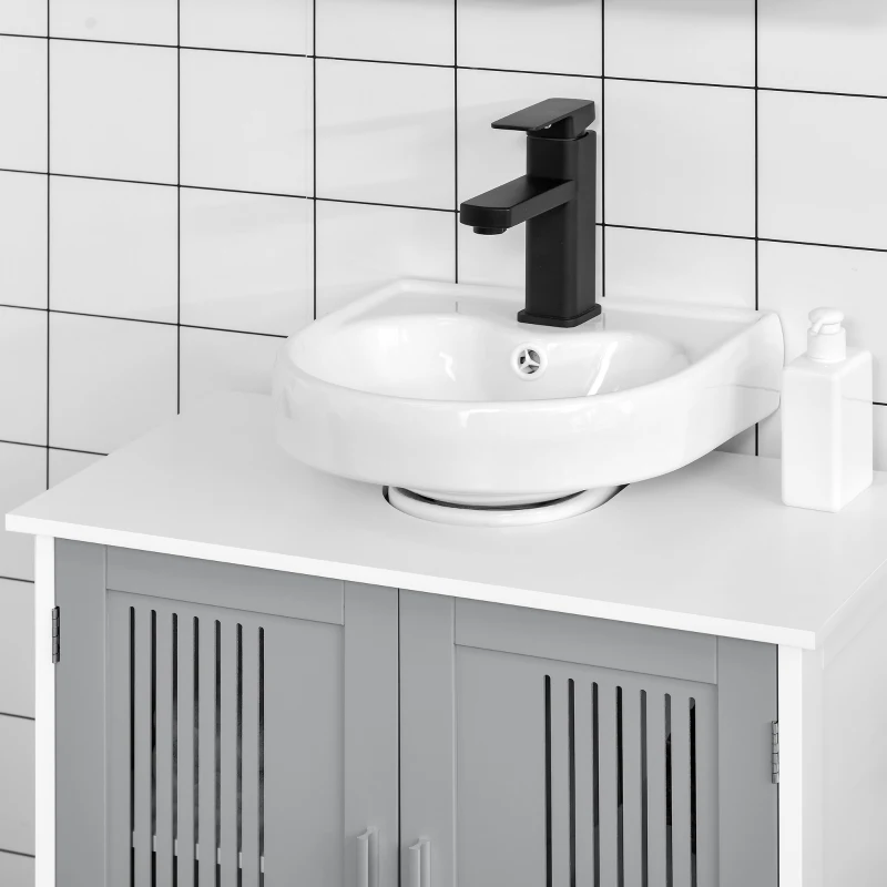 Close-up of white vessel sink with black faucet on a light grey vanity in tiled bathroom.