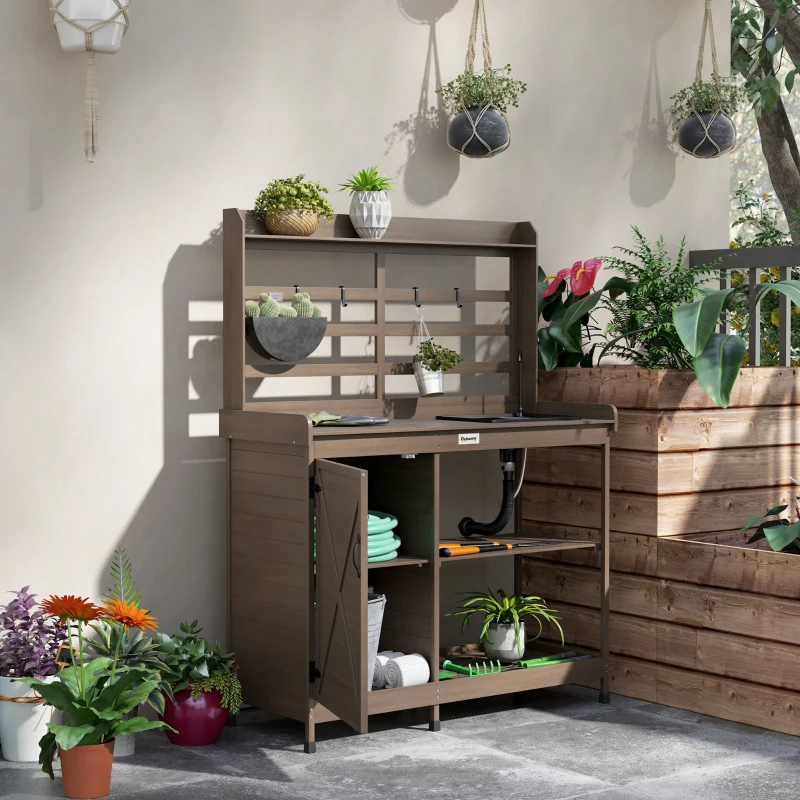 Outdoor wooden potting bench with water tap and deep sink for plant care.