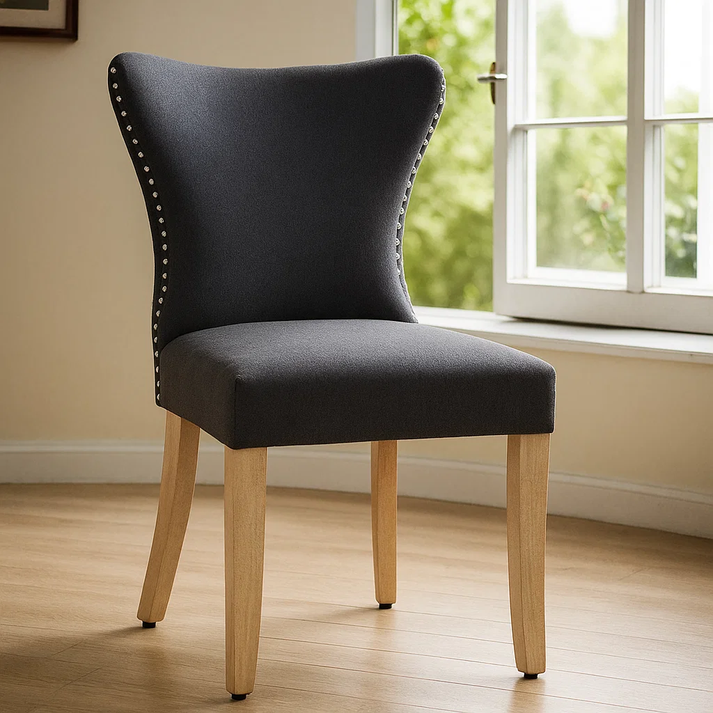 Dark grey upholstered dining chair air drying near window in bright, well-ventilated indoor room.