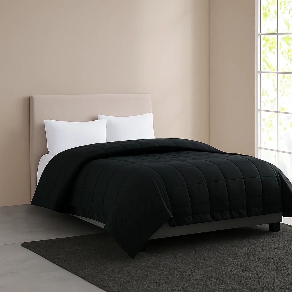 Black quilted blanket on a modern bed.