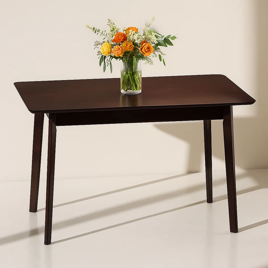 Dark wood table with vase of orange and yellow roses.