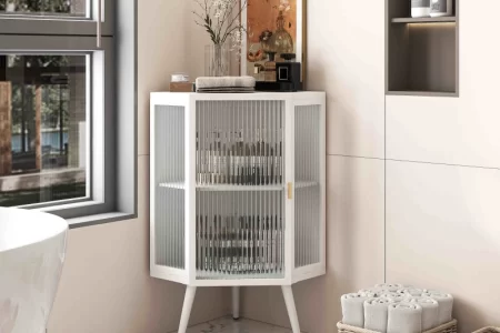 Stylish bathroom corner cabinet with glass doors and decor.