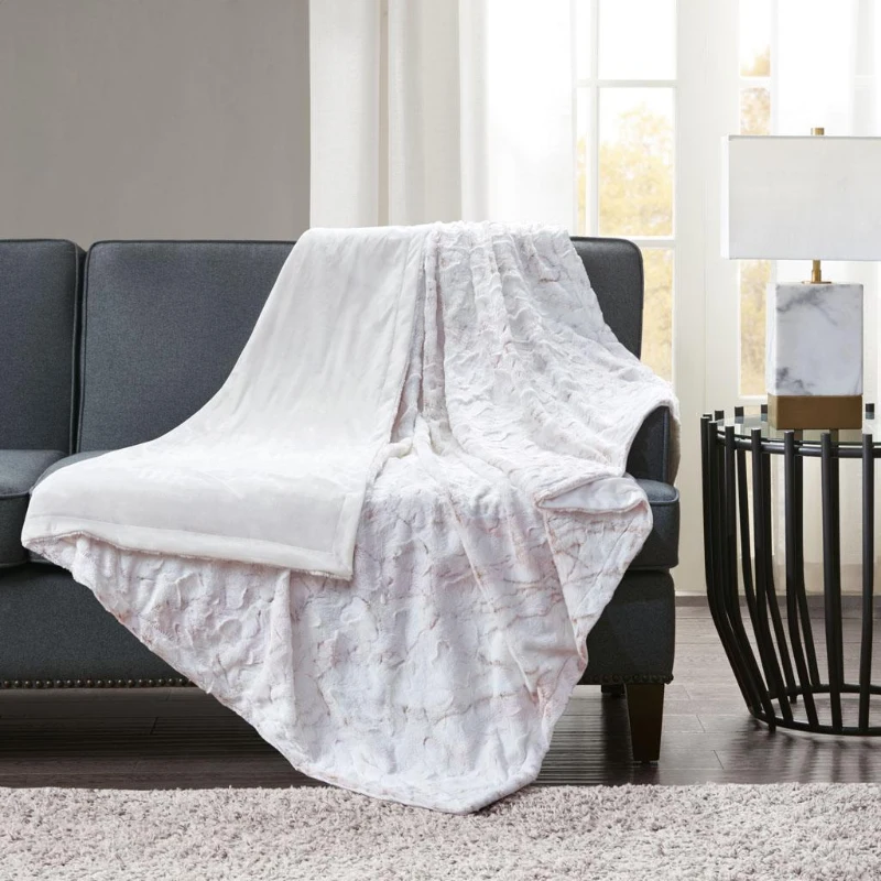 Textured white throw blanket on dark sofa