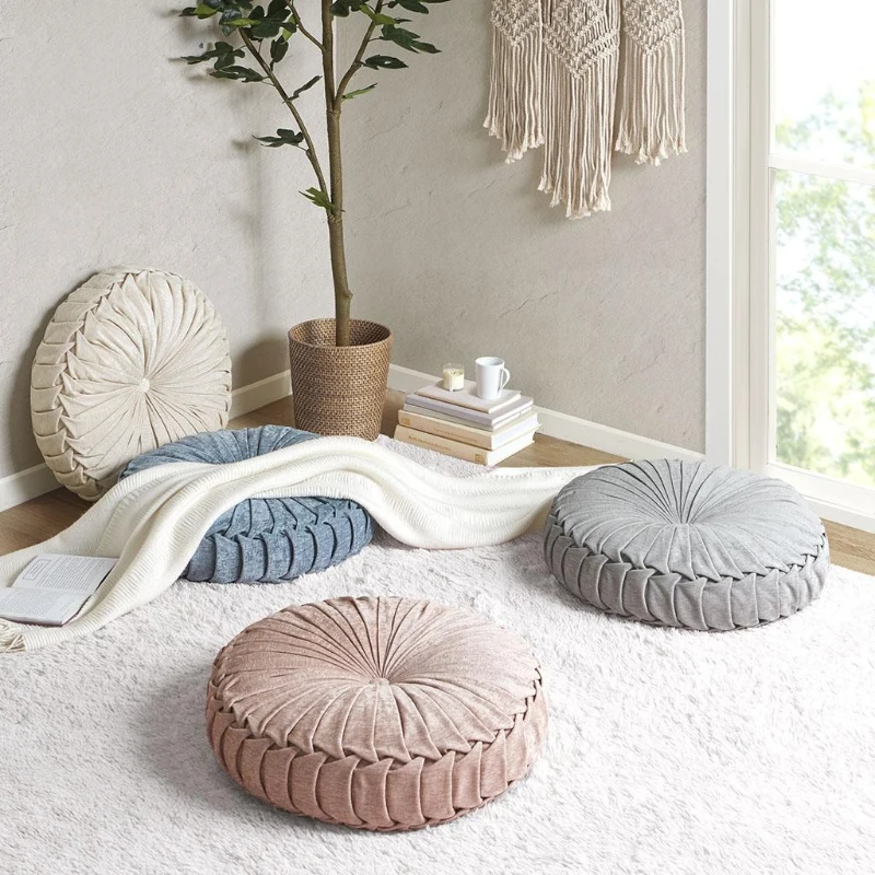 Assorted round cushions in cosy living room with rug and books.