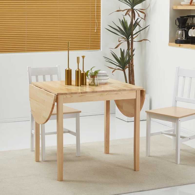 Wooden drop-leaf dining table with white chairs in bright room.