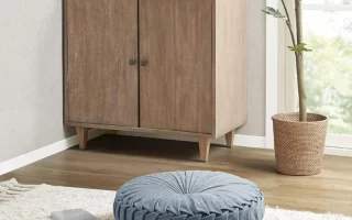 Blue round floor cushion placed on cream shaggy rug near cabinet.