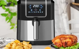 Modern air fryer with fried chicken and snacks on table.
