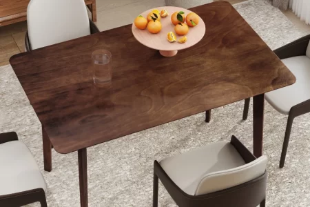 Clean and polished wood dining table with fruit centerpiece in a cozy dining room.