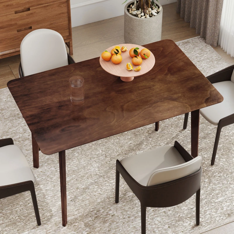 Clean and polished wood dining table with fruit centerpiece in a cozy dining room.
