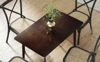 Overhead view of dining table with four chairs and green plant vase.